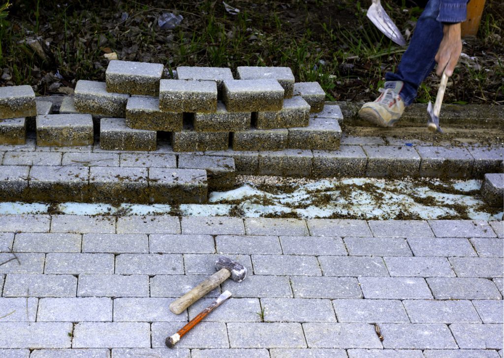 Maintenance work on paving with interlocking paving stones. Building materials industry; Concrete products for road or sidewalk construction.